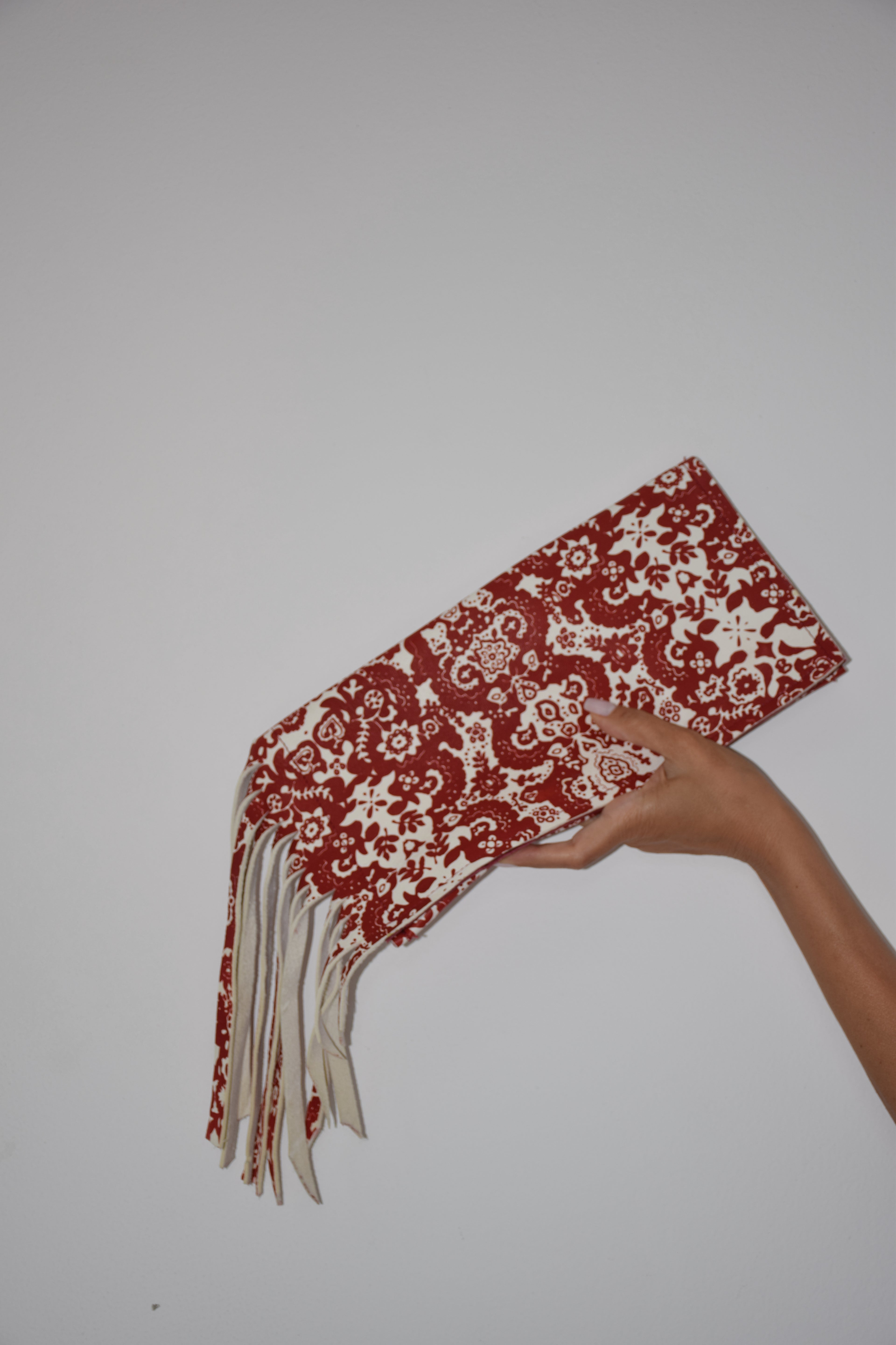Clutch con frangie fantasia rosso e bianco