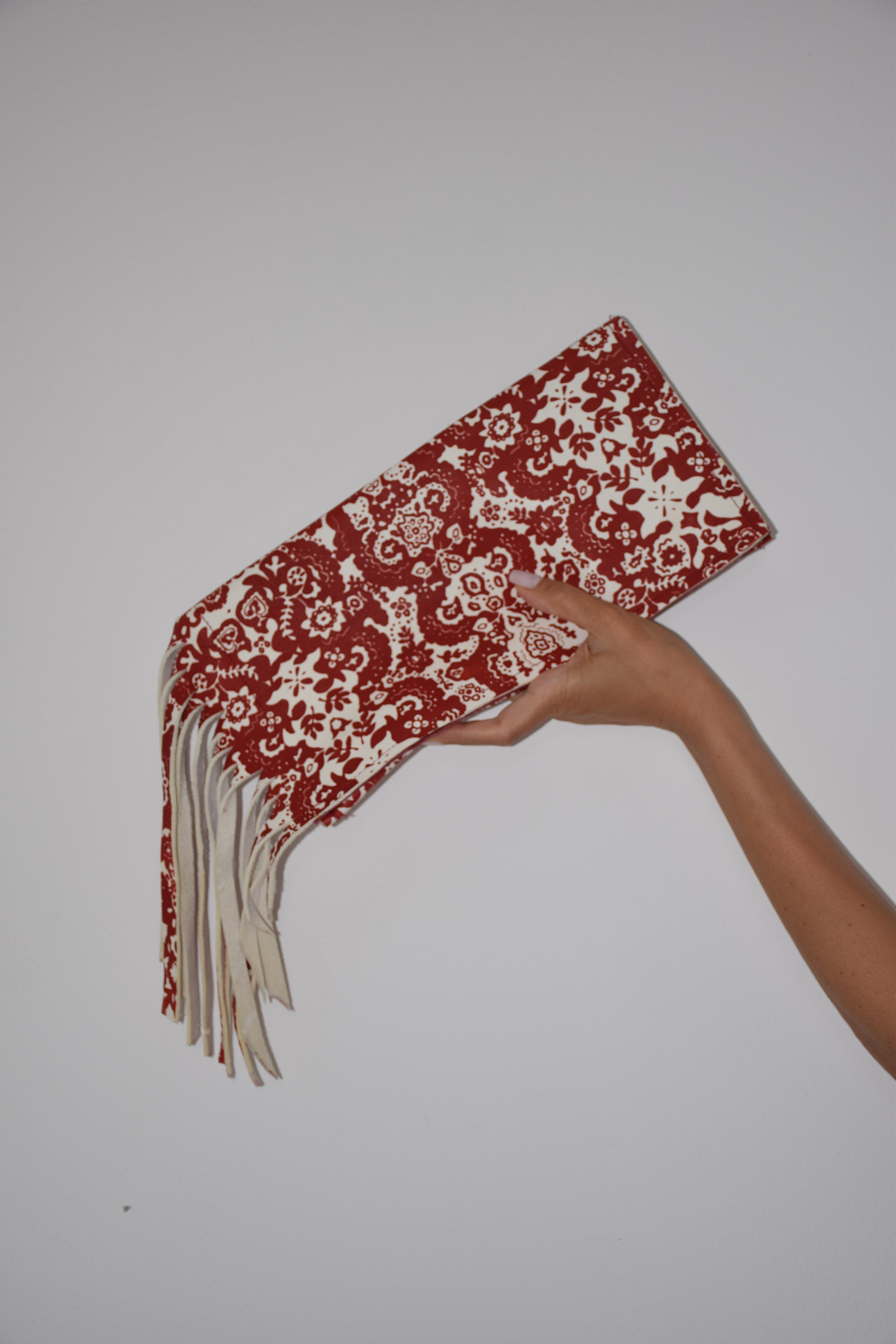 Clutch con frangie fantasia rosso e bianco